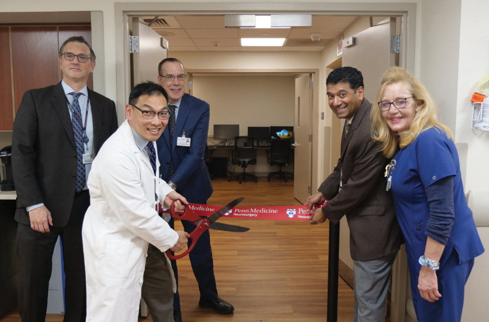 Daniel Yoshor, MD; John Y. K. Lee, MD, MSCE; Dan Wilson, MBA, BSN, RN, FABC; Suneel Nagda, MD; and Kitty Sweeney, MSN, RN, CMSRN, standing around a red ribbon in front of the Gamma Knife Suite entrance at the grand re-opening 